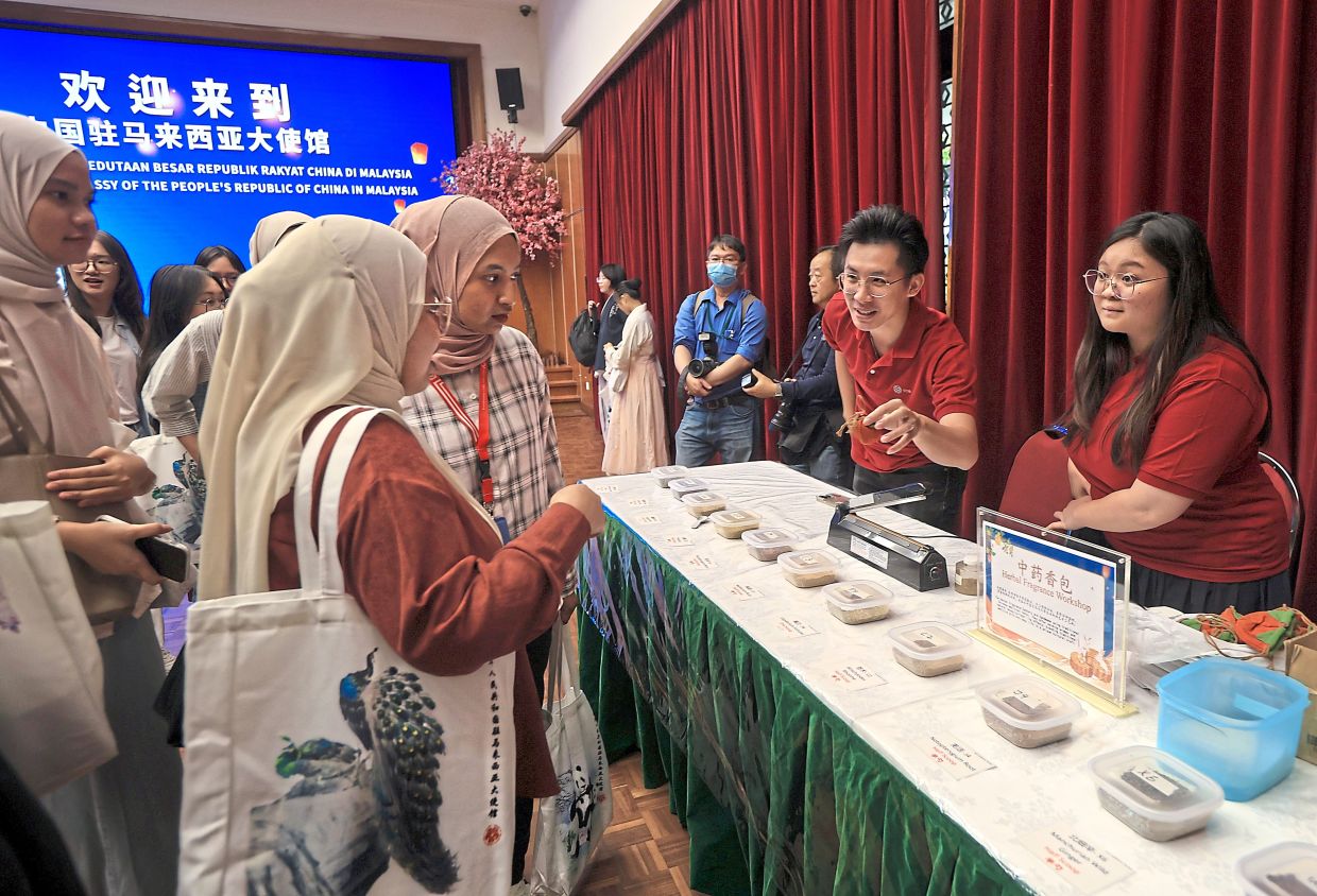 Students learning about traditional Chinese medicine at the herbal fragrance sachet workshop.
