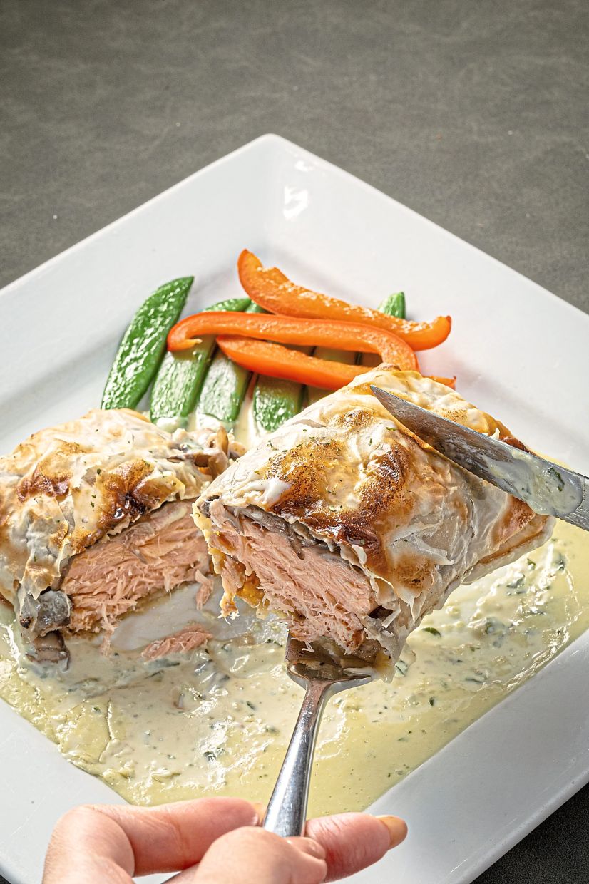Baked Salmon Strudel, with a light pesto cream sauce that complements the fish.