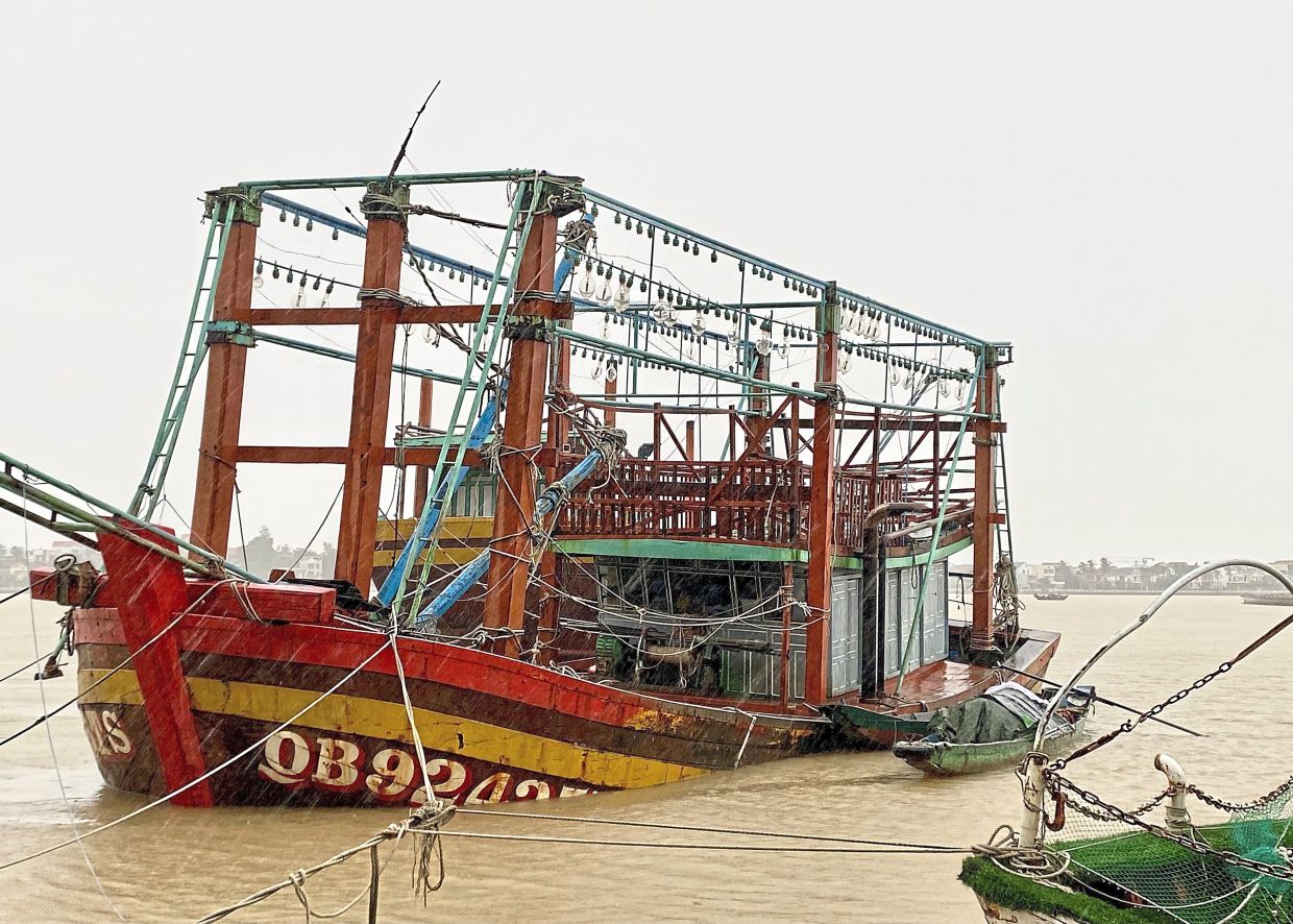 A fishing boat is grounded in the aftermath of typhoon Bualoi in Quang Tri. — AFP/Reuters/AP