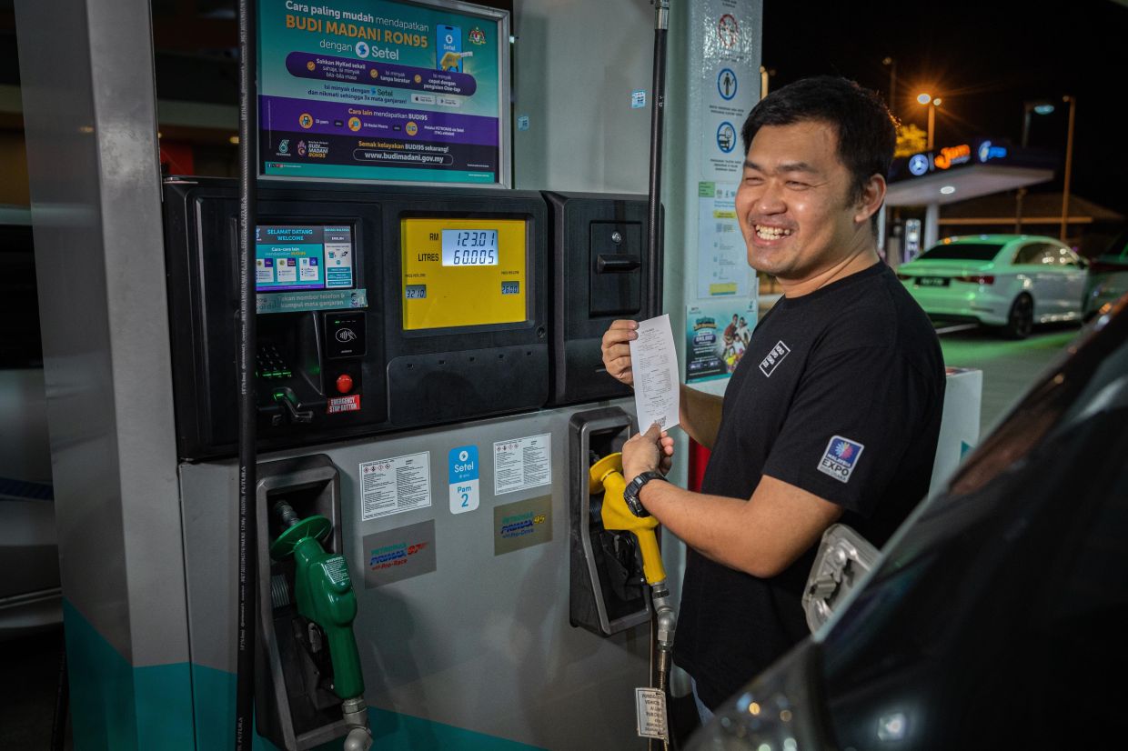 Budi95: Early birds take advantage to be among the first to benefit 2 42-year-old toy model designer Oh Jee Shyan waited until midnight to be among the first to enjoy the RON95 petrol subsidy in Ipoih. - Photo: Bernama