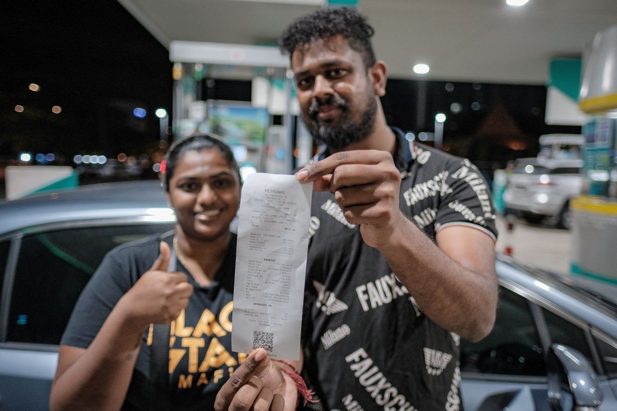 Budi95: Early birds take advantage to be among the first to benefit 3 R. Puspalata (left) and her husband V. Arvinthan showing off their receipt after taking advantage of the Budi95 subsidy in Johor. - Photo: Bernama