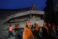 Relatives weep for scores of missing children after deadly Indonesia school collapse