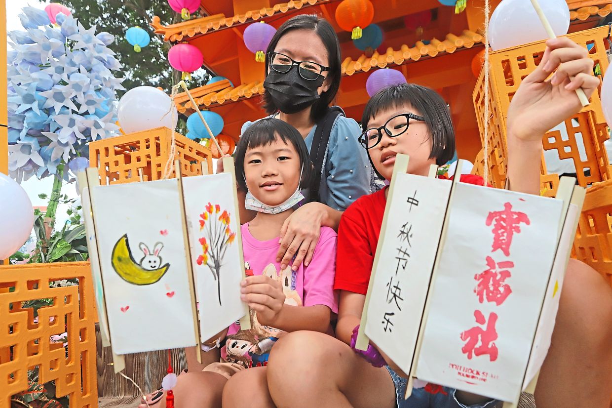 Chuan with her children Yu Hann (right) and Yu Chiee showing off their handmade lanterns.