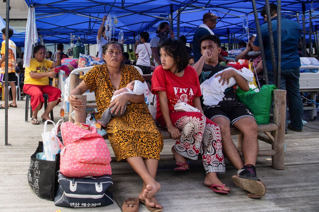Patients wait for their turn to receive regular medical consultation outside the Bogo hospital on Oct 1. - AFP