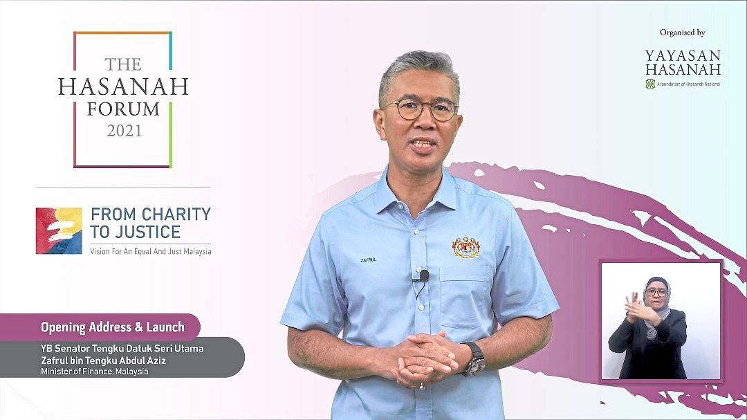 Wan Zuraidah (inset) providing sign language interpretation during an address by Investment, Trade and Industry Minister Tengku Datuk Seri Zafrul Abdul Aziz at a forum.