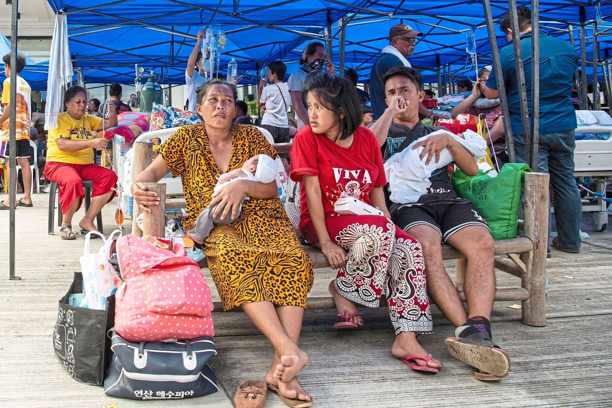 Tense situation: Patients waiting for their turn to receive treatment outside the provincial hospital in Bogo City. — AFP