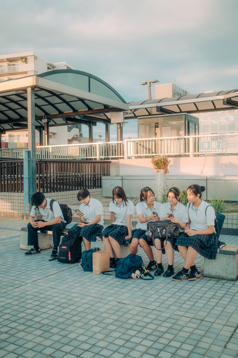 High schoolers in Toyoake, Japan look at their mobile phones on Sept 29, 2025.