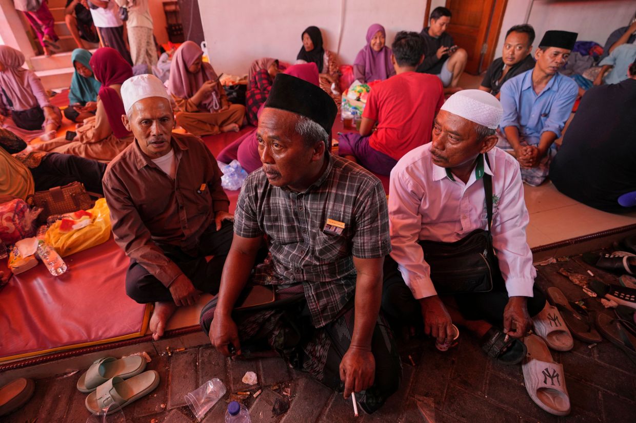 Mohammad Solehoddin, (center), whose son has not been accounted for after a building under construction collapsed Monday at an Islamic boarding school, waits with other family members as rescue efforts are underway, in Sidoarjo, East Java, Indonesia, Thursday, Oct 2, 2025. - Photo: AP