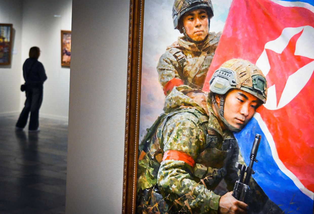 A visitor walks next to the painting 'The Sons Of The Motherland' by Kim Yeong Chan.Photo: AFP 