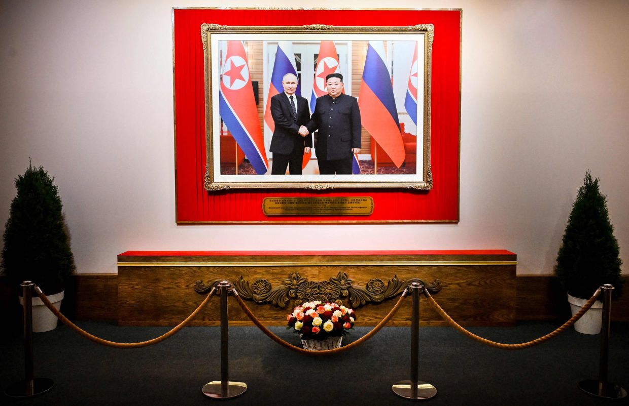 A huge photo of Putin and Kim meeting each other in Pyongyang on June 19, 2024, is seen at the exhibition in Moscow. Photo: AFP 