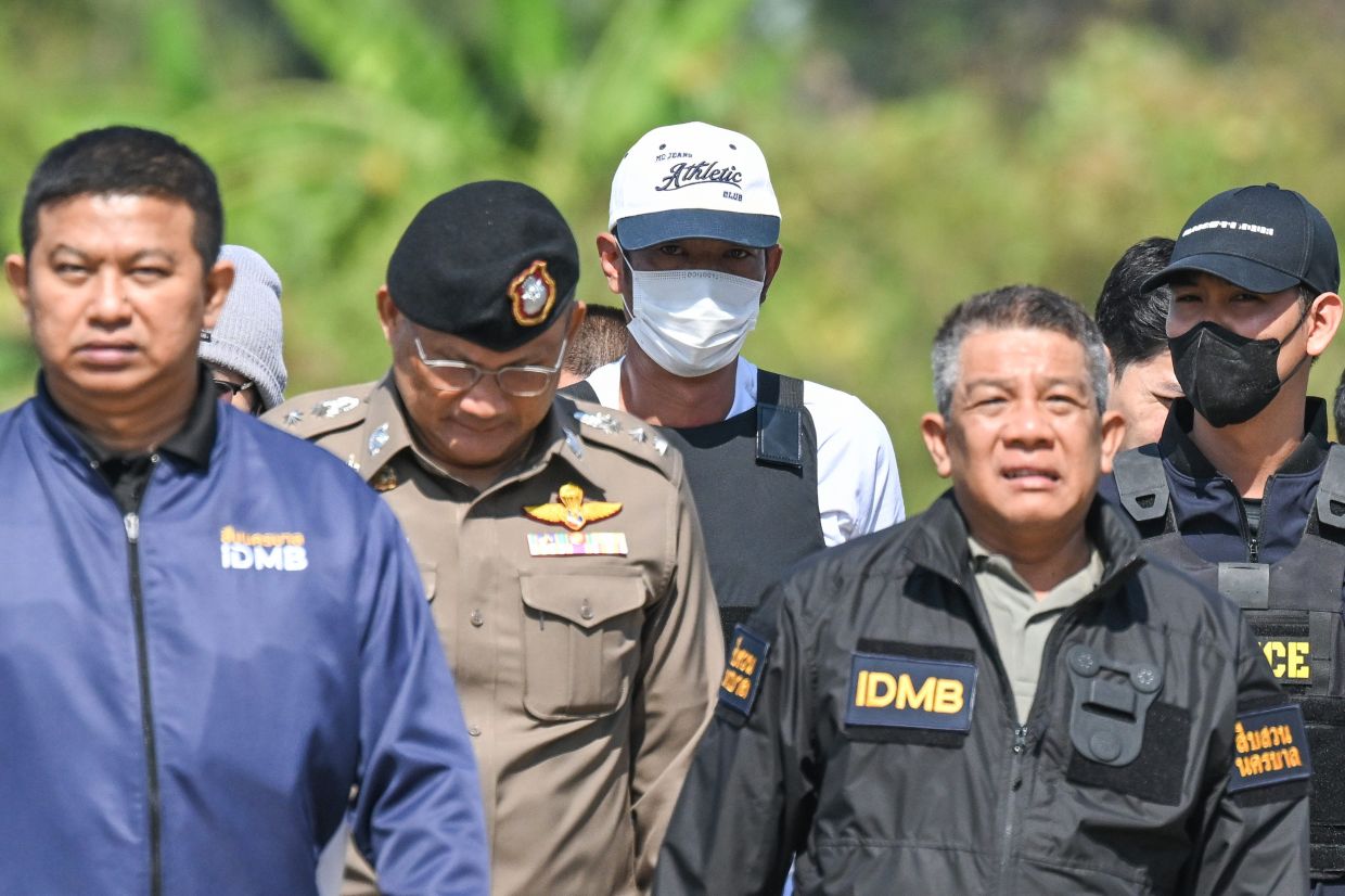 Thai police officers escort Ekkalak Pheanoi (centre), the accused in the shooting of Cambodian politician Lim Kimya, after he was deported from Cambodia, in Bangkok, Thailand, on Jan. 11, 2025. The court sentenced the gunman who killed a Cambodian politician to life in prison on Friday, Oct 3, 2025. (AP Photo/Panumas Sanguanwong)