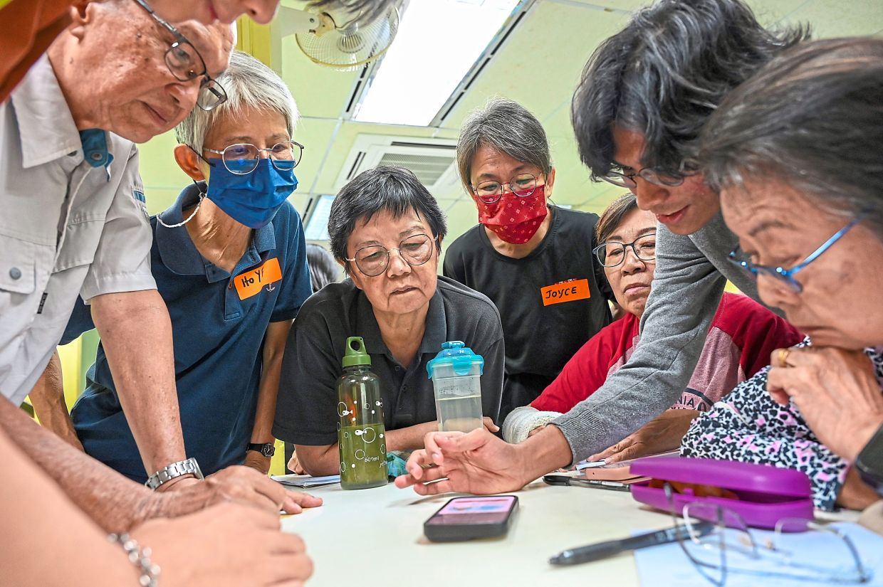 Participants huddle around a volunteer during the SS2 senior citizens digital literacy class at Touch Centre in SS2, Petaling Jaya. — Photos: IZZRAFIQ ALIAS, LOW BOON TAT and ADANI ZAIDI/The Star