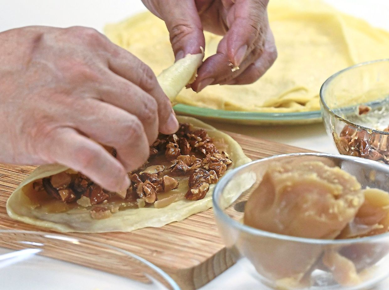 Recipe calls for layer of lotus paste and caramelised almonds to be folded into the pancake before deep-frying until crisp and golden (right).