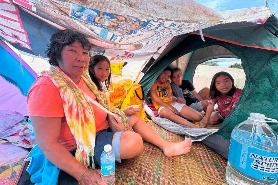 Grandmother Deborah Amor watches over her grandchildren inside their tent set up at the evacuation site for earthquake survivors in San Remigio town in Cebu, Philippines, on Oct 3, 2025. -- ST PHOTO: MARA CEPEDA