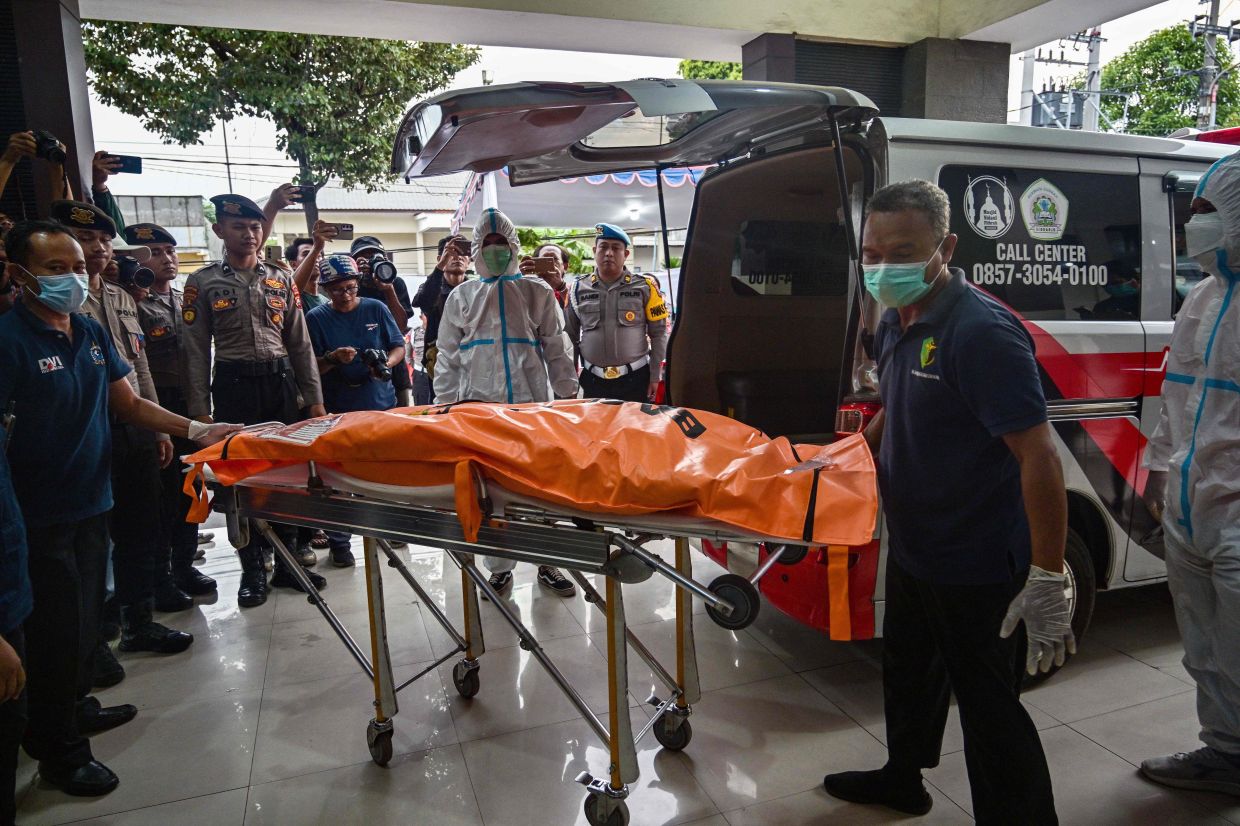 The remains of a student killed in a building collapse at the Al Khoziny Islamic boarding school is brought in a body bag to the Bhayangkara hospital in Surabaya, East Java province, on Saturday, October 4, 2025. The death toll in an Indonesian school collapse rose to 17 on October 4, officials said, as rescuers deployed heavy machinery to recover dozens more victims believed still buried under the rubble. -- Photo by Juni KRISWANTO / AFP