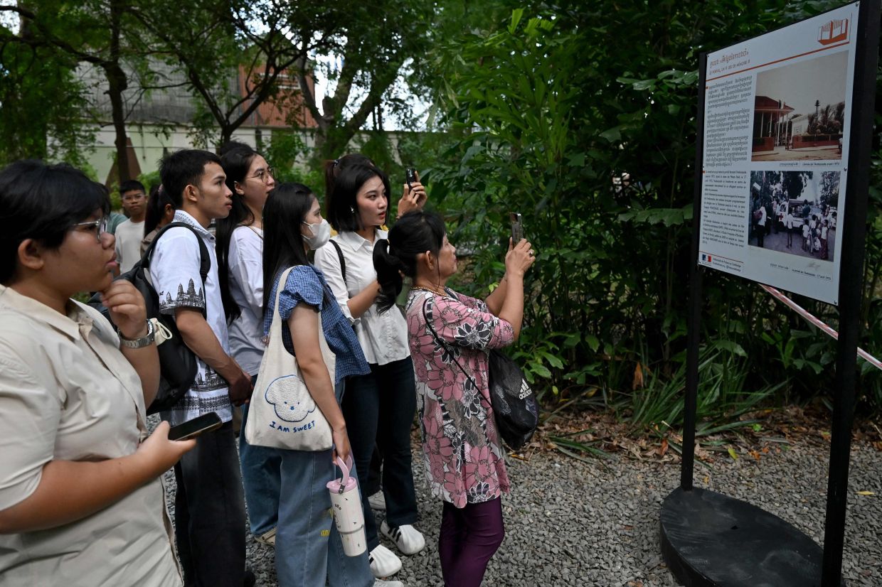 Cambodians look at an information board as they visit the French Embassy which opened its doors to the public for its annual French Embassy Heritage Day in Phnom Penh on Saturday, October 4, 2025. -- Photo by TANG CHHIN Sothy / AFP