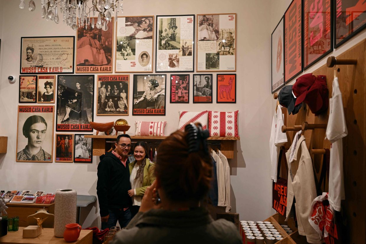 A staff member takes photographs of visitors at the museum's gift shop. Photo: AFP