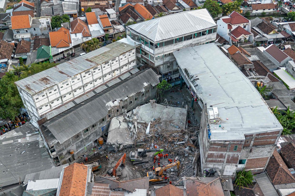 An aerial view shows rescuers searching for victims at the Al Khoziny Islamic boarding school in Sidoarjo, East Java, on October 5, 2025, after a multi-story building at the school collapsed during prayers, killing at least 37 people with 26 others still missing, according to an official. - Photo: AFP