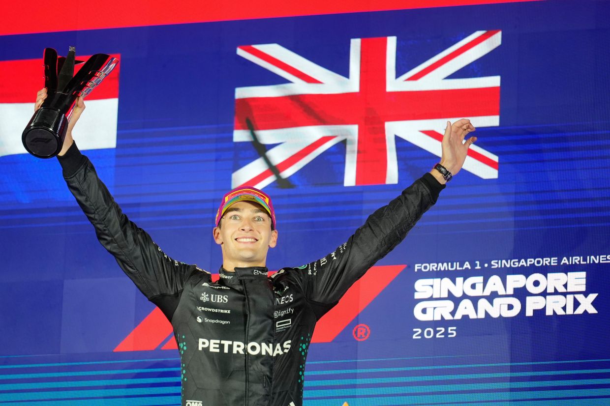Mercedes driver George Russell of Britain celebrates after winning the Singapore Formula One Grand Prix at the Marina Bay Street Circuit in Singapore. -- AP Photo/Vincent Thian