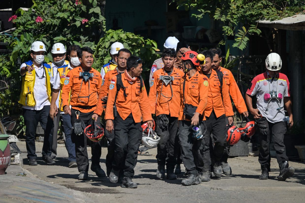 Rescue team members walk out from the site of the collapsed Al Khoziny Islamic boarding school in Sidoarjo, East Java, on Monday, October 6, 2025, as recovery efforts continue. The death toll from the collapse has risen to 59, according to officials. -- Photo by JUNI KRISWANTO / AFP