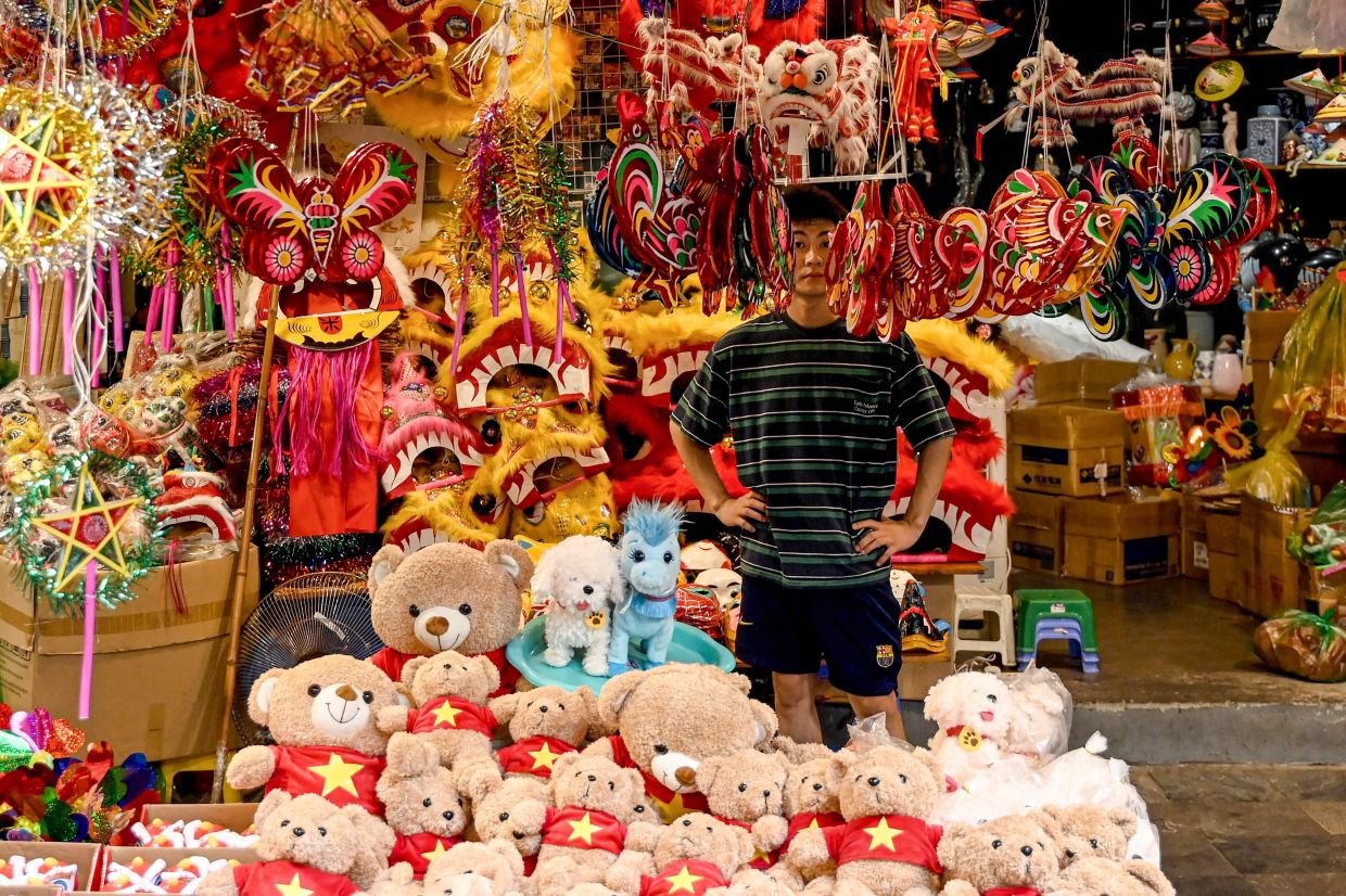 A vendor waits for customers at a shop selling Mid-Autumn Festival decorations and goods in Hanoi's Old Quarter on Monday, October 6, 2025. -- Photo by Nhac NGUYEN / AFP