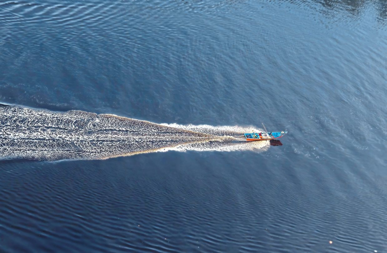 A lone boat carving its path across the Baram river. The river is a true highway and lifeline into Sarawak.