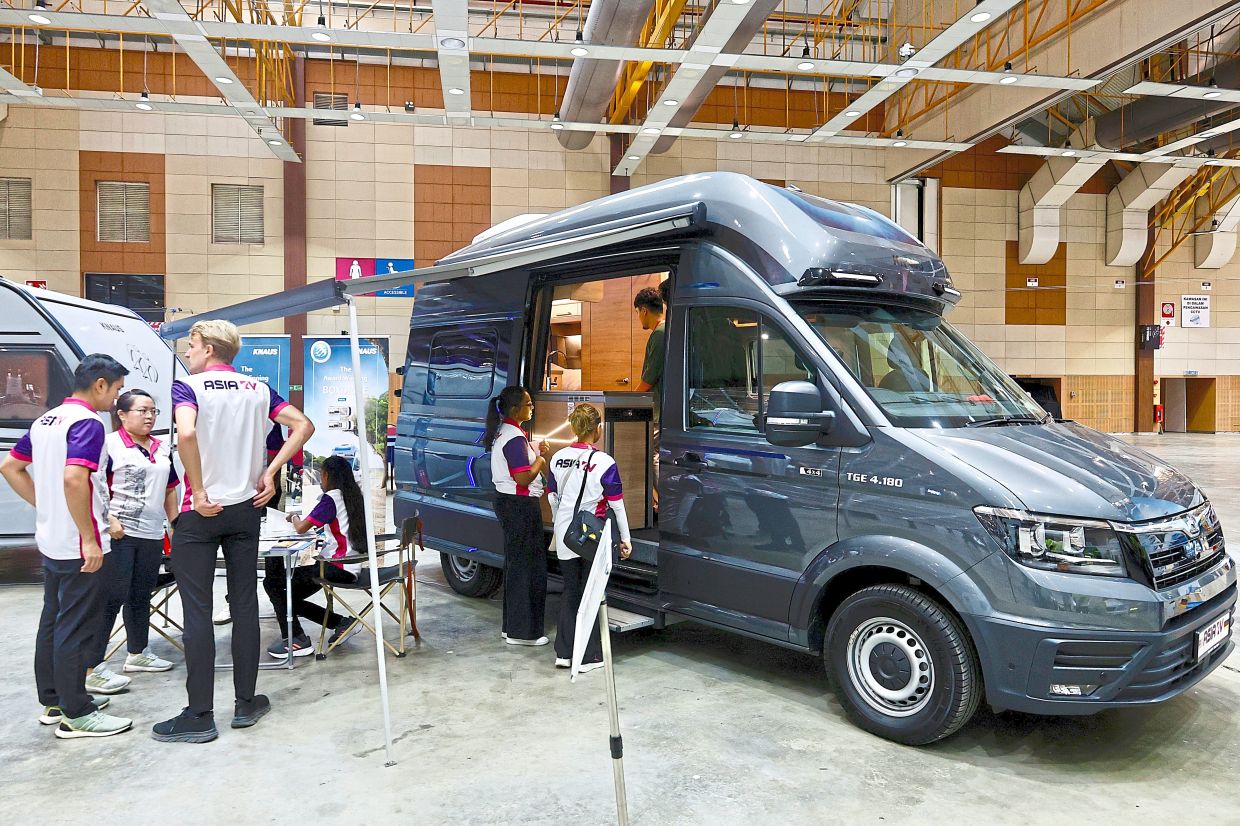 Asia RV staff showcasing a camper van to visitors at the event. — FAIHAN GHANI/The Star