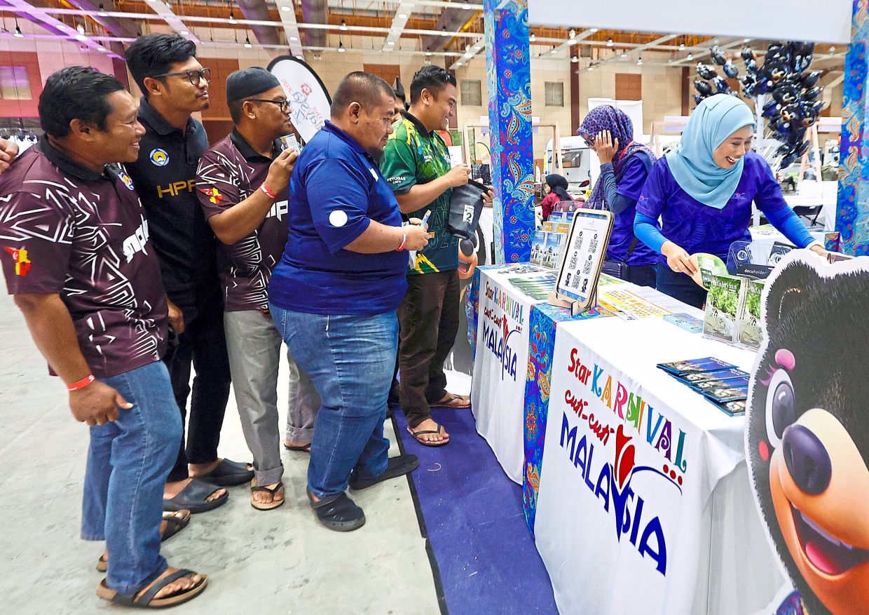 Visitors gathering at the Tourism Malaysia booth during TGO, where travel information and local highlights draw strong interest. — FAIHAN GHANI/The Star