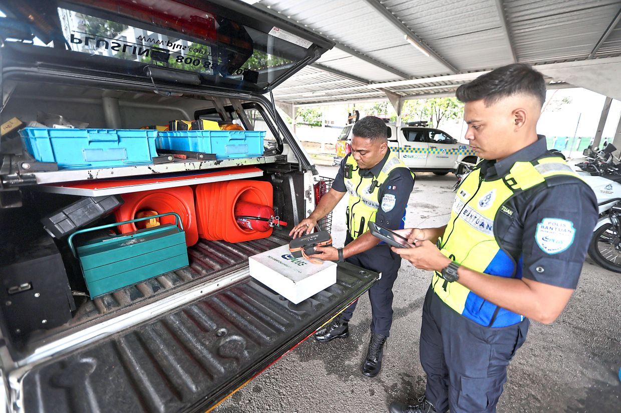 Mohd Hafidz and Mohd Hakimi (right) preparing safety equipment before their shift.