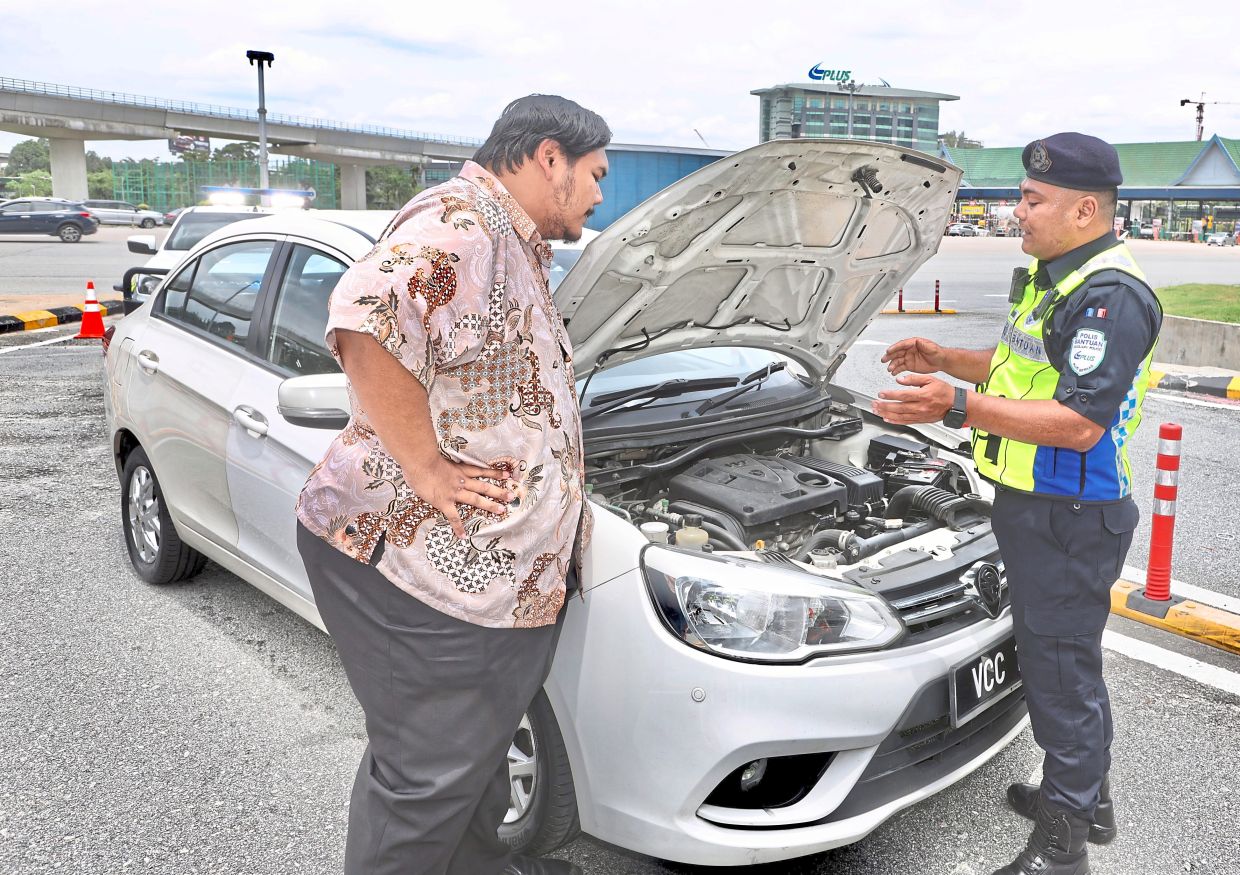 Mohd Hafidz attending to a motorist with car problems.