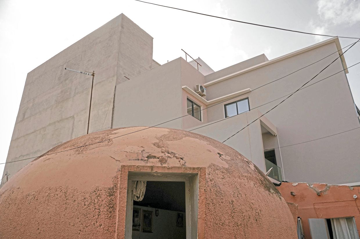 Ndiaye's house surrounded by a big concrete building. — CARMEN ABD ALI/AFP