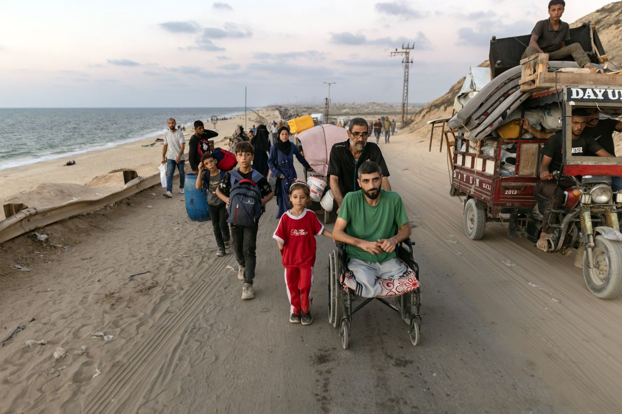 Hamza Salem, in wheelchair; his daughter Rital; and their family flee to southern Gaza on Sept 14, 2025, after the Israeli Army begins a new assault on Gaza City. — Saher Alghorra/The New York Times