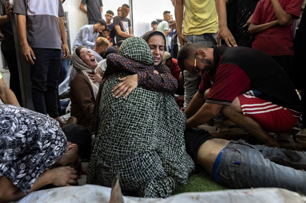 People mourn those killed in an attack on June 30, 2025, on a cafe near Gaza City. More than 67,000, or one in every 34 Gazans, have been killed, according to local health officials. — Saher Alghorra/The New York Times