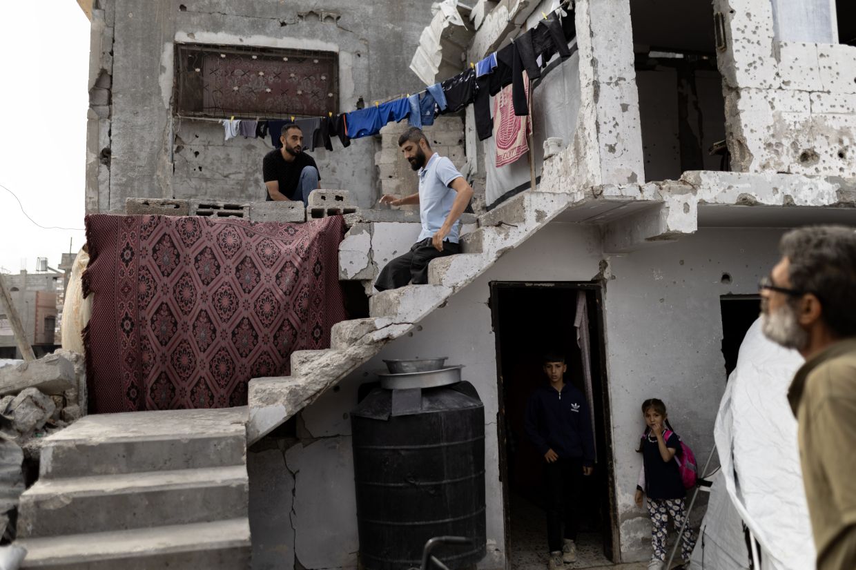 Hamza Salem, who lost both his legs in an israeli attack, descends the steps of the wreckage of his home in Gaza City in May 2025. — Saher Alghorra/The New York Times