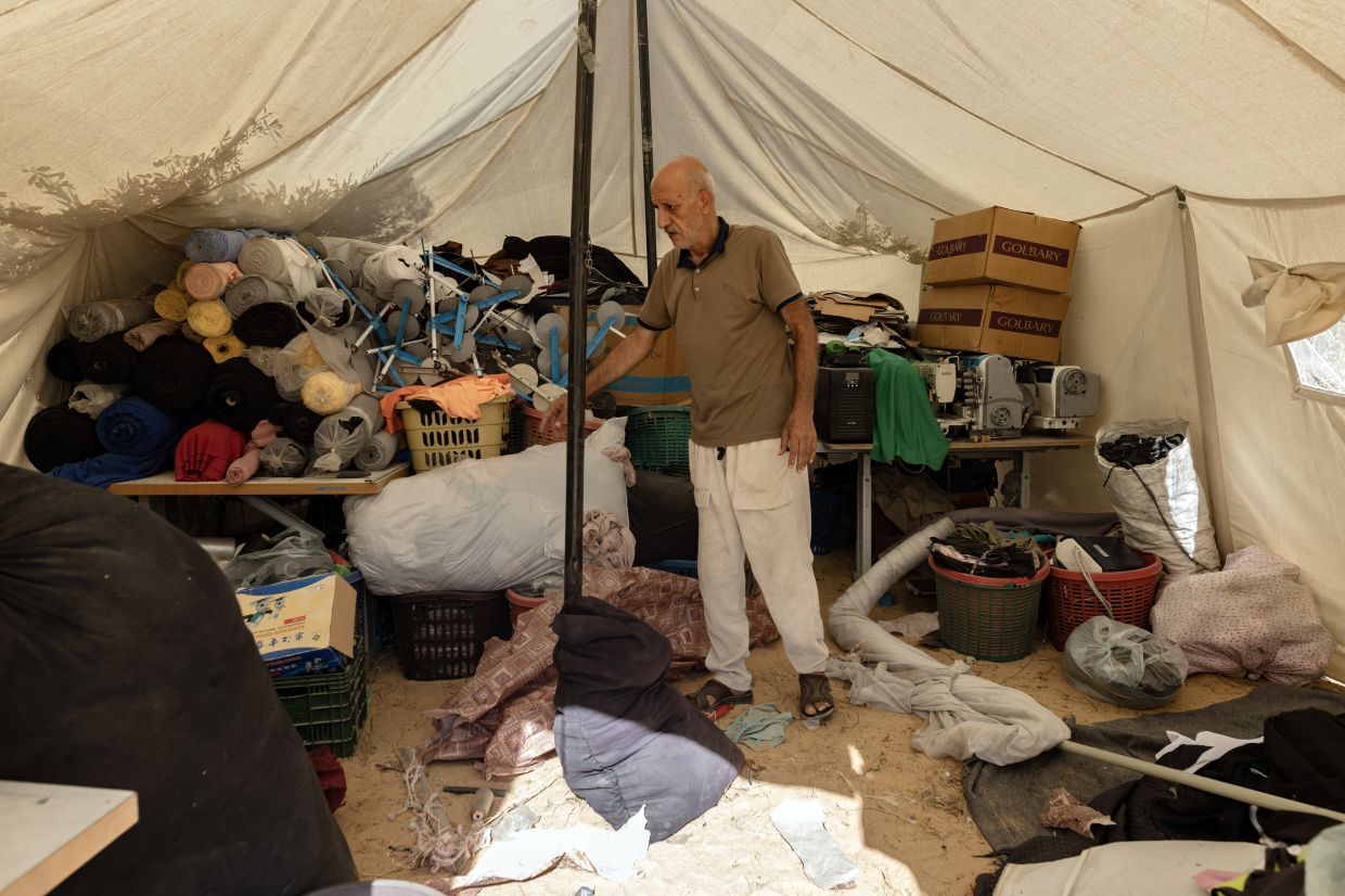 Hassan Shehada, 61, in the tent where he stores his cloth and equipment at the Deir al-Balah camp. — Saher Alghorra/The New York Times