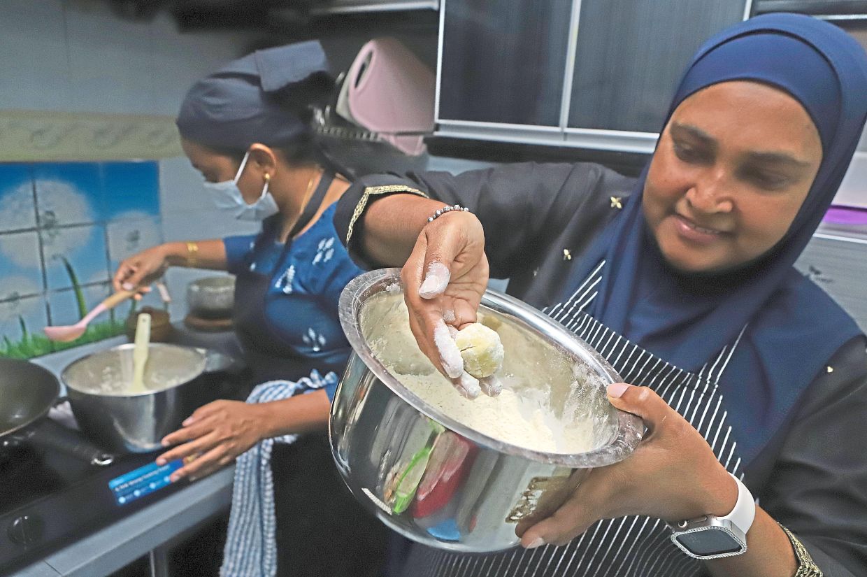 Sha Nanthini (left) and her sister-in-law Fairuza Abdul Rahman making nei urundai for the festive season.