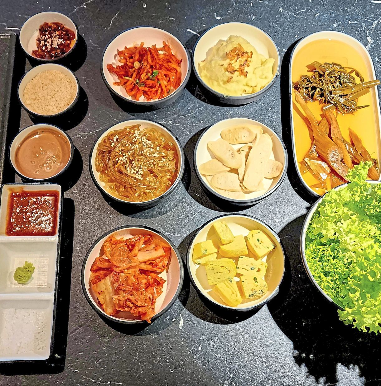 The meal comes with a range of complimentary banchan as well as dipping sauces and salts to pair with the barbecue. — ABIRAMI DURAI/The Star 