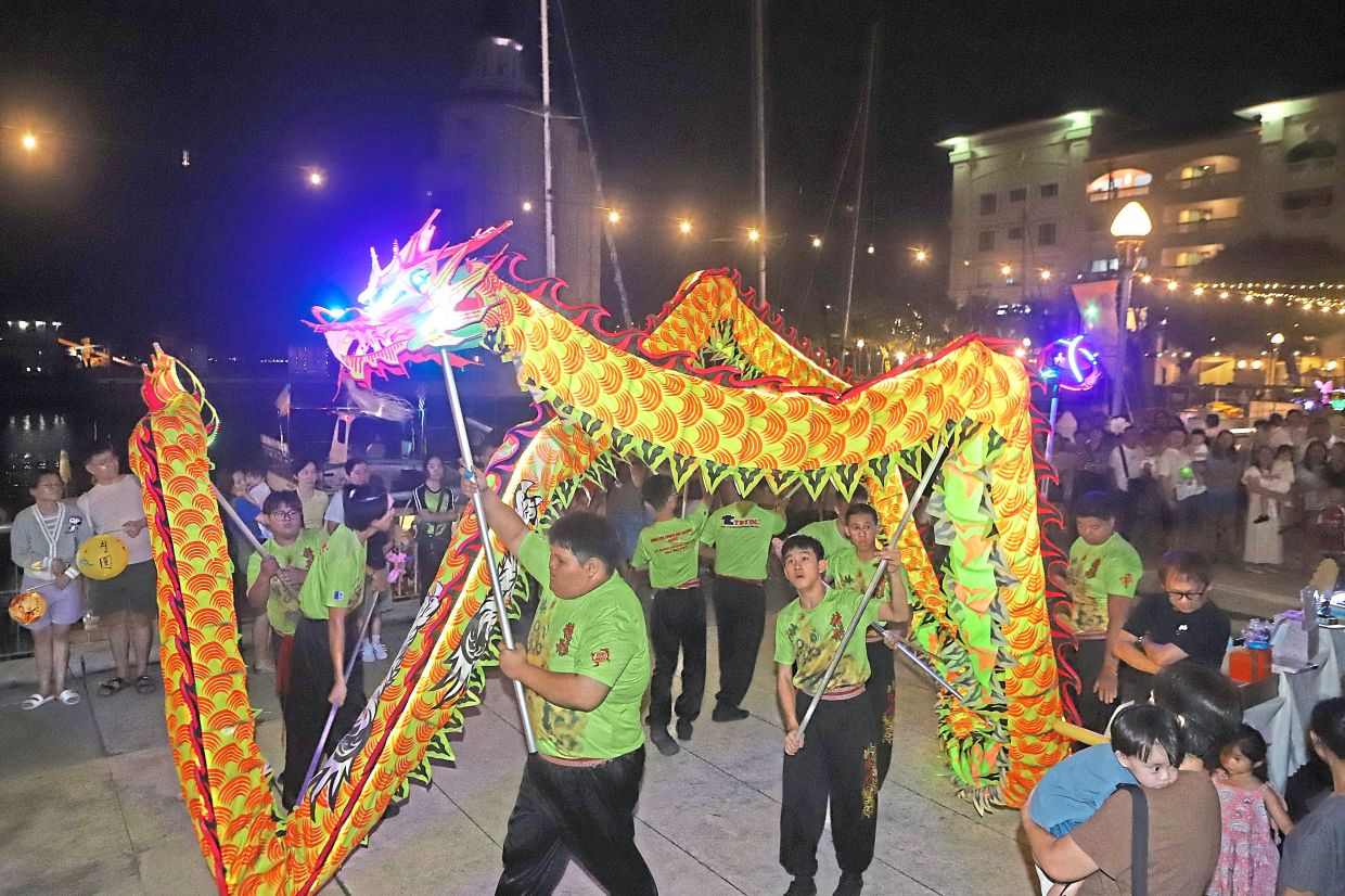 LED dragon dance performance captivating the crowd during the celebration at Straits Quay Retail Marina.