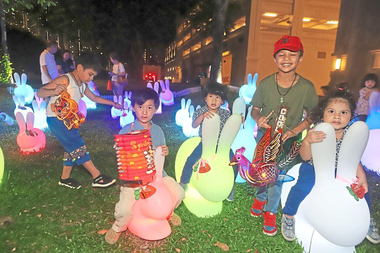Trishen (with red cap) holding a traditional lantern at the Love of Bunnies Garden with other children.