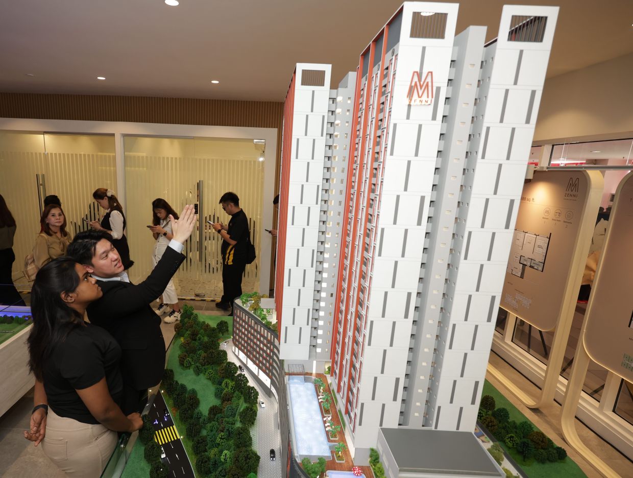 Prospective buyers looking at the model of the project during launch of the gallery.