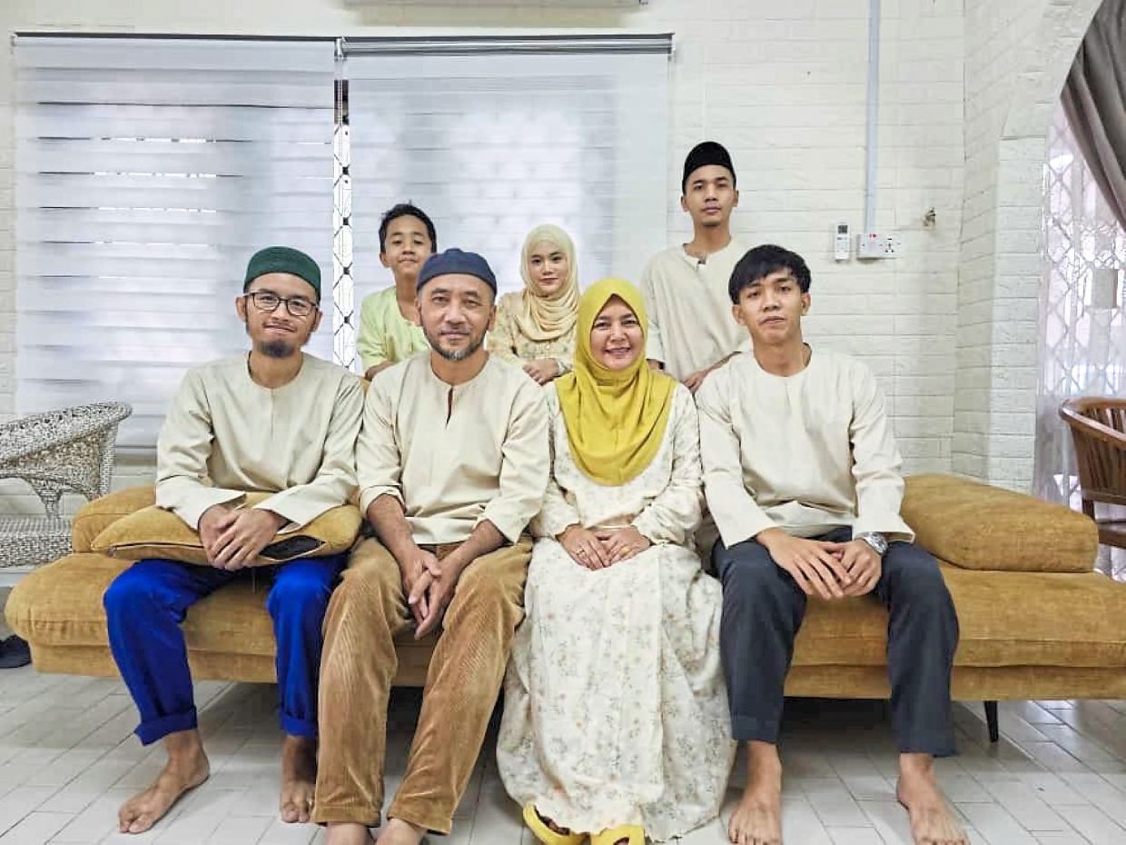 Fatimah (standing, centre) and Arba (seated, second from right) with their family members. Photo: Arba Ali