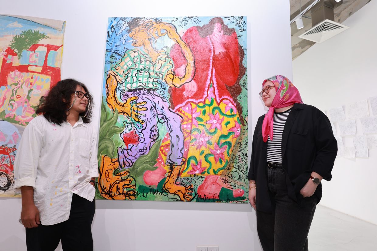 Kide and his wife, Ika Sharom, pose beside their joint artwork 'Mato-Mata' at his latest solo exhibition, which marks his 10th year in the art scene. Photo: The Star/Kamarul Ariffin
