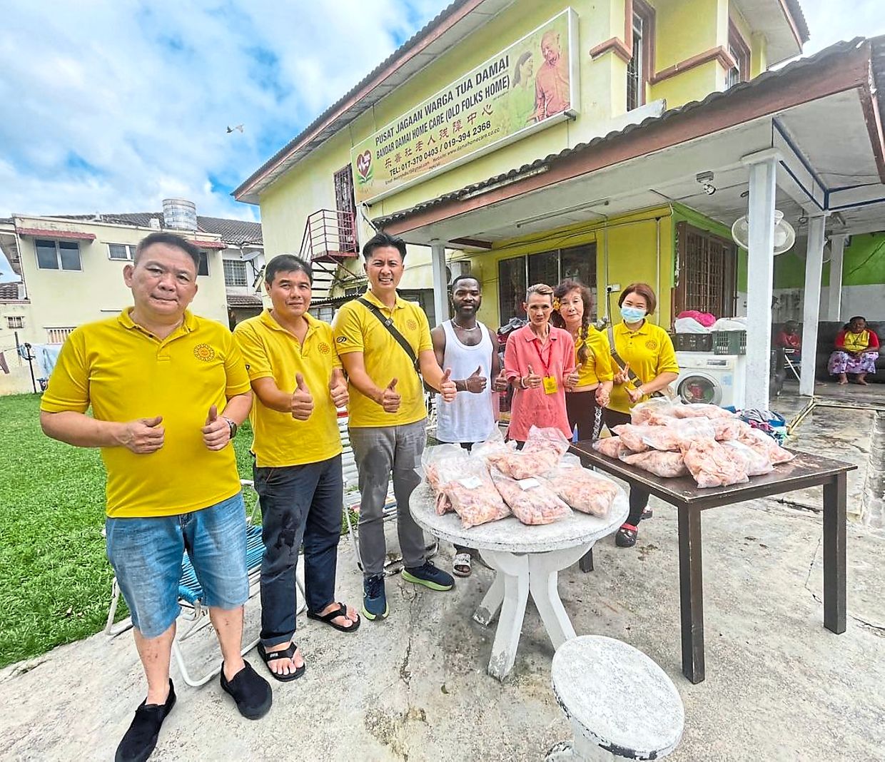 Beacon Mart personnel offering aid in the form of frozen meat to Bandar Damai Home Care, an old folks home in Kuala Lumpur.
