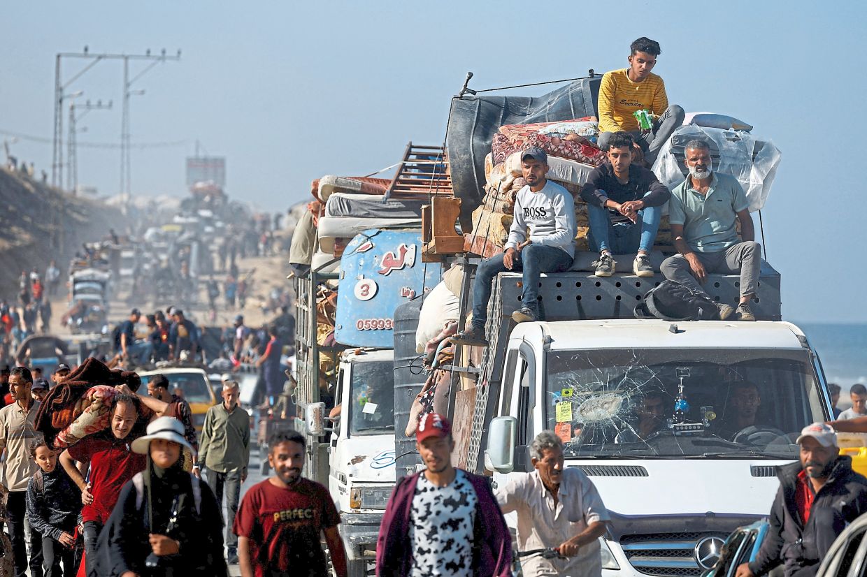 Palestinians, who were displaced to the southern part of Gaza at Israel's order, make their way along a road as they return to the north, amid a ceasefire between Israel and Hamas in Gaza. — Rueters