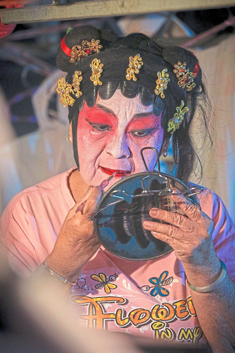 Putting on thick face paint and all ready in full costume for the performance on stage.