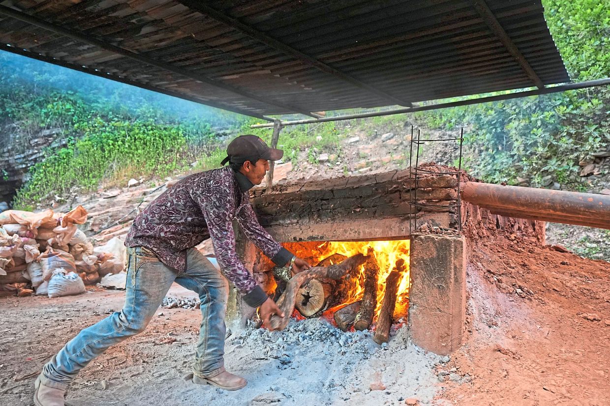 Martinez feeds the fire in the artisanal furnace where mercury ore is cooked in San Joaquin, Mexico.