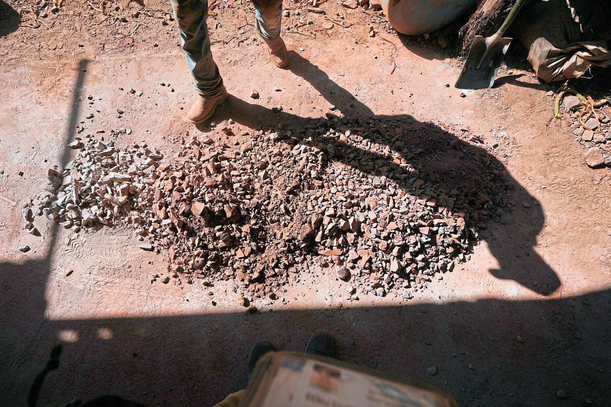 Martinez prepares mercury ore before placing it in a furnace tube to bake.