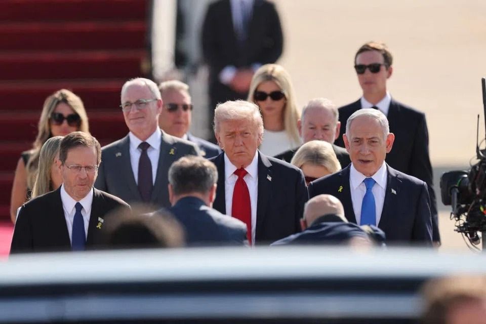 US President Donald Trump (centre) and his entourage are being welcomed by Israeli Prime Minister Benjamin Netanyahu (right) after arriving at Ben Gurion Airport on Oct 13. -- PHOTO: AFP