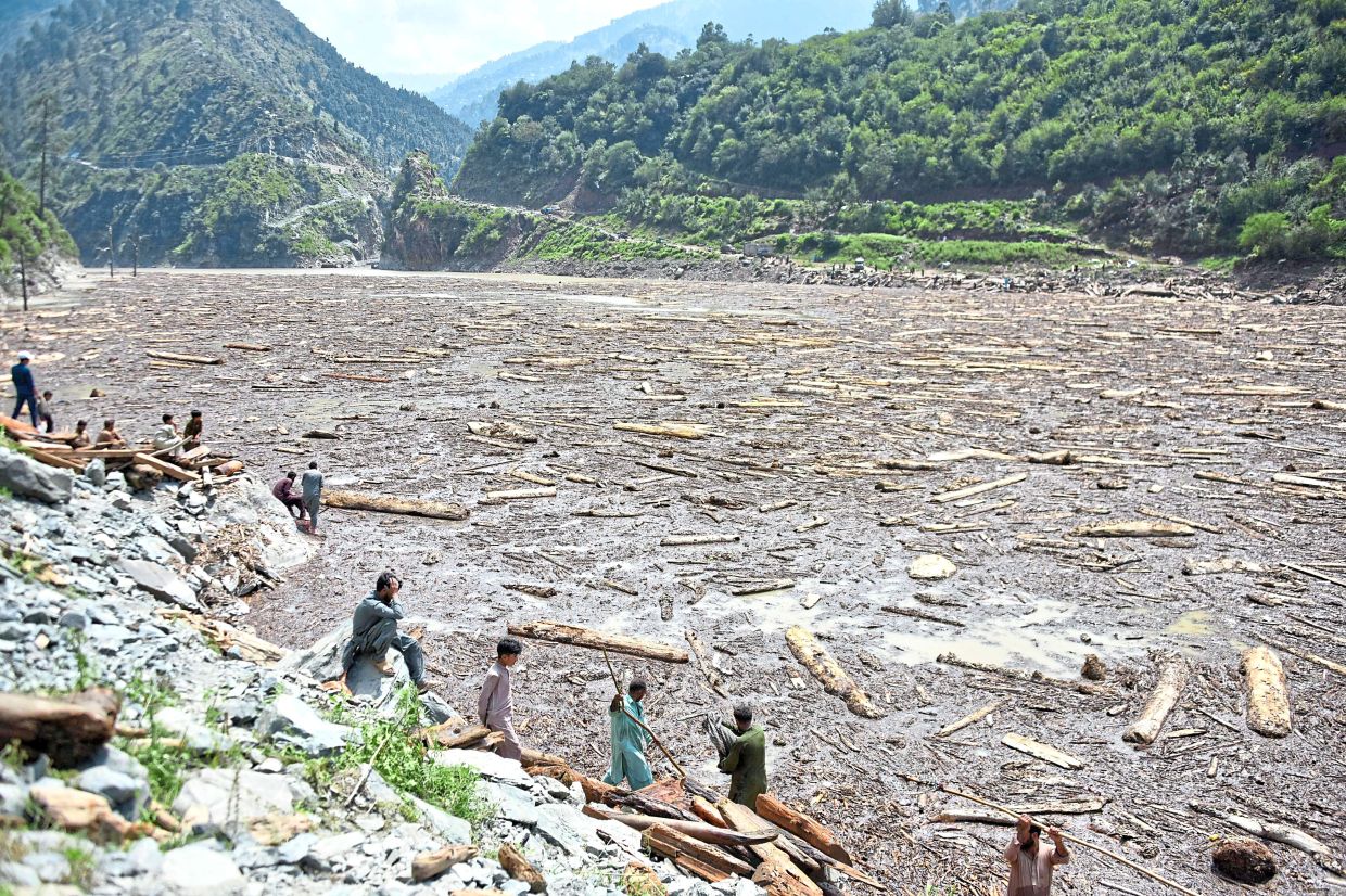 Locals collecting wood from the Noseri Dam near Muzaffarabad, capital of Pakistan-administered Kashmir. -AFP