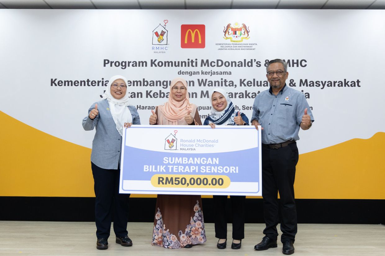 Shamsidar (far left) handing over a mock cheque representing a RM50,000 contribution to Taman Sinar Harapan Tuanku Ampuan Najihah principal Khairunnisa (second from right) for the construction of the sensory therapy room in Taman Sinar Harapan Tuanku Ampuan Najihah, in the presence of Rosmahwati (second from left) and Nasri (far right).